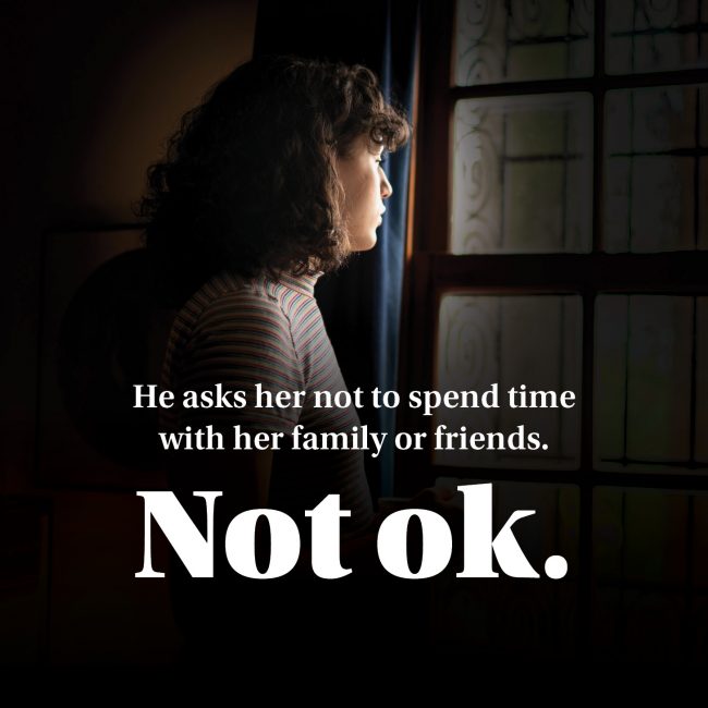 Poster text reads “He asks her not to spend time with her family or friends. Not ok.” — campaign on recognizing isolation.